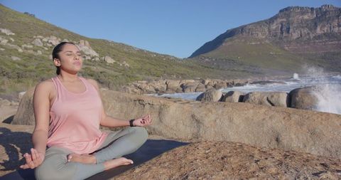 Meditating Woman Practicing Yoga in Tranquil Coastal Setting
