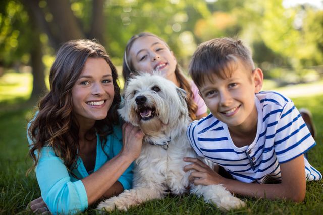 Family enjoying a sunny day in the park, perfect for promoting family activities, outdoor fun, pet companionship, and leisure time. Ideal for use in advertisements, brochures, and websites related to family services, pet care, and outdoor recreation.