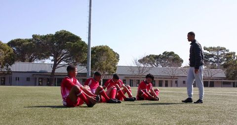 Soccer coach instructing young players during outdoor training