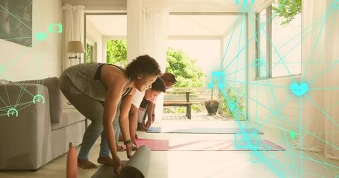 Preparing group of women unrolling yoga mats in sunlit living room with fitness overlay