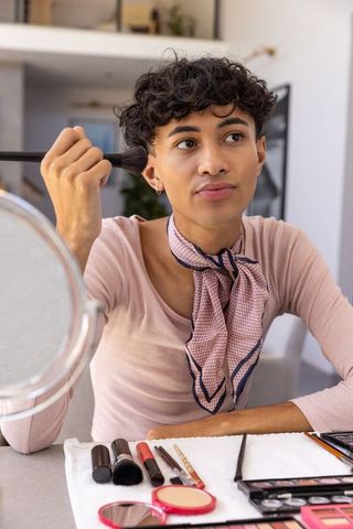 Man applying makeup at home reflecting modern grooming trends