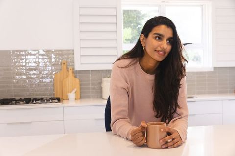 Woman Enjoying Coffee in Modern Minimalist Kitchen