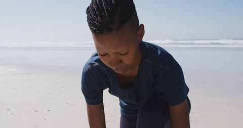 Active Woman Tying Shoe on Sunny Beach Ready for Yoga - Download Free Stock Images Pikwizard.com