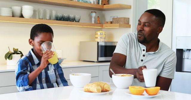 Father and Son Enjoying Breakfast Together at Modern Kitchen Table - Download Free Stock Images Pikwizard.com