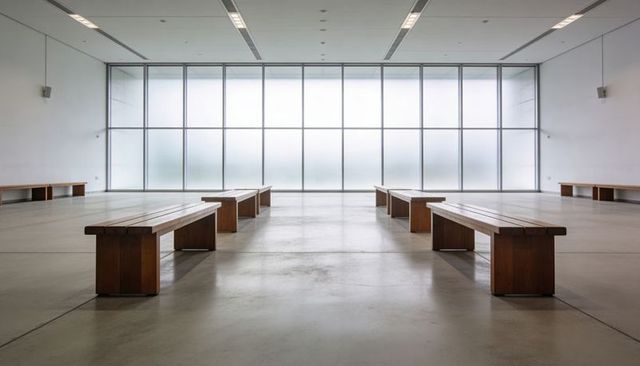 Minimalist gallery featuring symmetrical wooden benches and frosted glass wall