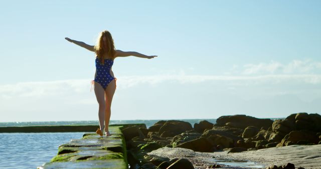 Woman Balancing on Rocky Shore in Swimsuit at Sunset - Download Free Stock Images Pikwizard.com