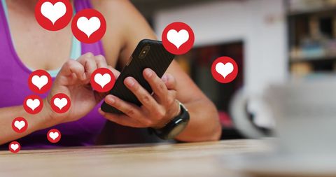 Female hand holding smartphone surrounded by heart icons