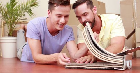 Young men choosing flooring samples during home renovation