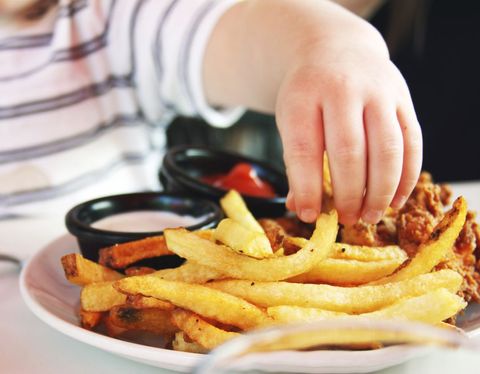 Child Enjoying French Fries with Dipping Sauces at Lunch