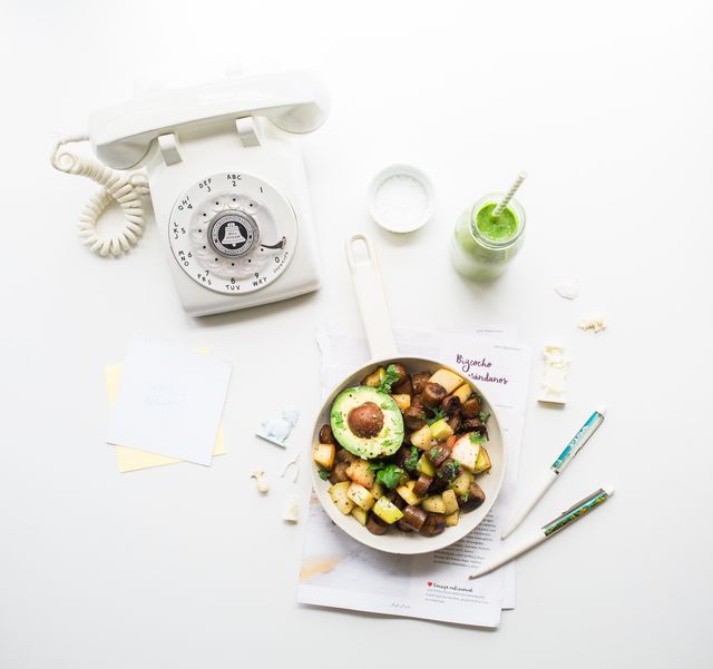 Image showcases a beautifully arranged healthy meal in a bowl with avocado and vegetables, placed next to a vintage rotary telephone and a green smoothie on a white background. Great for blogs, cooking websites, and vintage themed marketing material.