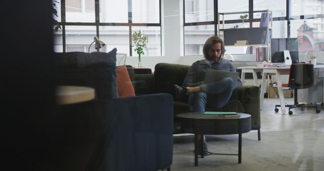 Man Working on Laptop in Modern Office Lounge Area - Download Free Stock Images Pikwizard.com