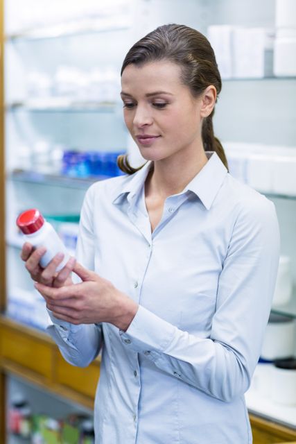 Pharmacist Checking Medication Bottle in Pharmacy - Download Free Stock Photos Pikwizard.com