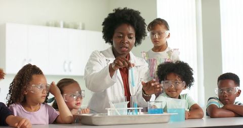 African American teacher demonstrating chemistry experiment for curious elementary students