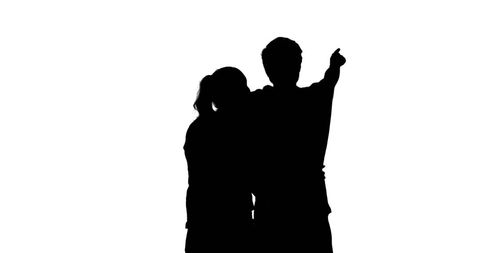 Couple Silhouette Embracing and Pointing Against White Background
