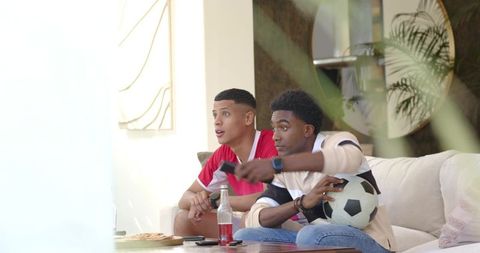 Diverse Friends Enjoying Game with Pizza and Beverage in Modern Living Room