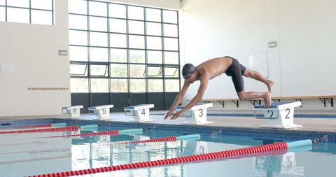 Competitive swimmer diving into pool in training session