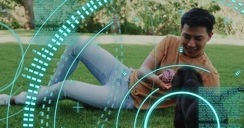 Asian man playing with dog on green lawn with augmented reality tech overlay