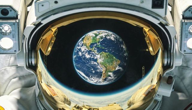 Astronaut helmet reflecting earth over south america during spacewalk above low orbit