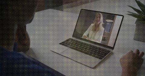 Man watching female presenter on laptop during remote meeting in minimalist office