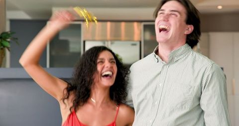 Cheerful Couple Throwing Confetti in Celebration