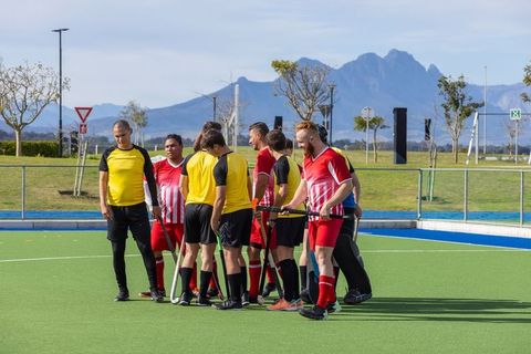 Diverse athletes shaking hands on field promoting sportsmanship