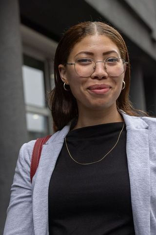 African american professional woman wearing glasses and gray blazer smiling outdoors