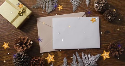 Displaying blank holiday card on rustic wood with pinecones, gold gift, silver fern