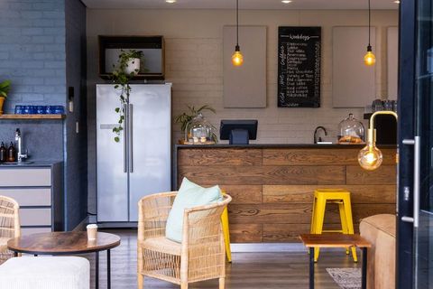 Cozy modern cafe interior with wooden service counter, pendant lights and pastries