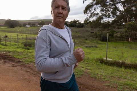 Senior Man Jogging Outdoors in Nature for Fitness and Wellness
