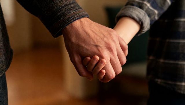 Holding interlocked hands between parent and child conveying warmth trust and care