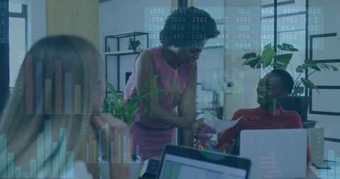 Women collaborating over analytics dashboards in modern office exchanging reports and insights