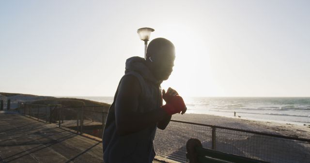 Determined Man Shadowboxing at Sunset on Beachfront - Download Free Stock Images Pikwizard.com