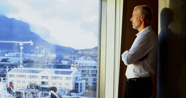 Thoughtful businessman looking outside the window in hotel room 4k