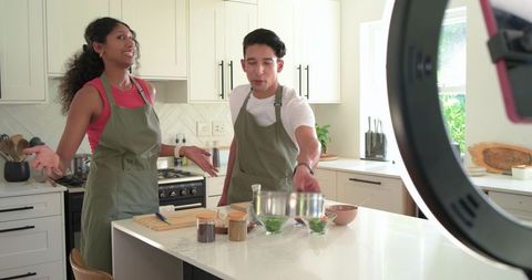 African American Hosts Filming Live Cooking Demo Mixing at Kitchen Island with Ring Light