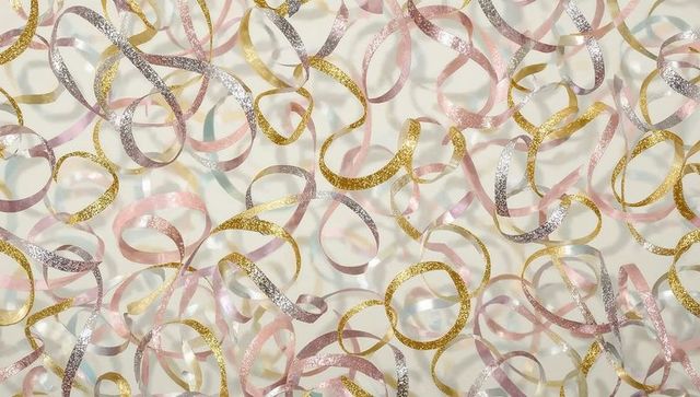 Gold pink glitter streamers curling on pastel background overhead flatlay celebration