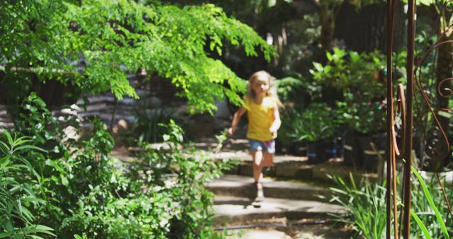 Happy caucasian girl wearing yellow t-shirt and blue shorts running in sunny garden - Download Free Stock Photos Pikwizard.com