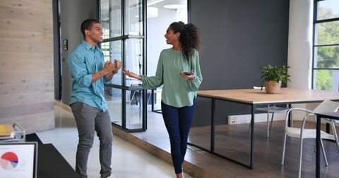 Happy Colleagues Celebrating Success in Modern Office Environment