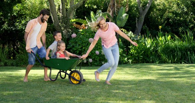 Happy Family Playing with Wheelbarrow in Sunny Garden - Download Free Stock Images Pikwizard.com