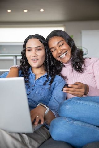 Friends relaxing together online shopping cozy living room setting