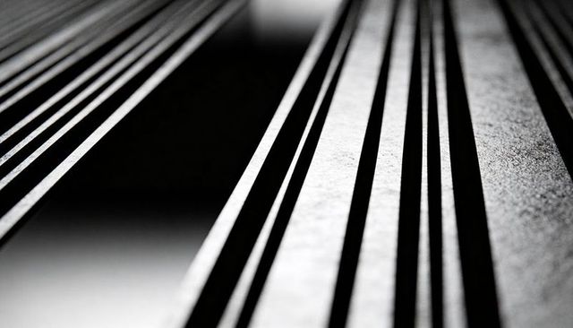 Diagonal metal slats casting bold shadows monochrome abstract architecture closeup