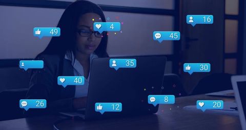 Professional woman responding to social media notifications typing on laptop in boardroom