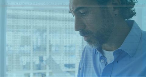 Elderly man examining digital data overlay in office setting