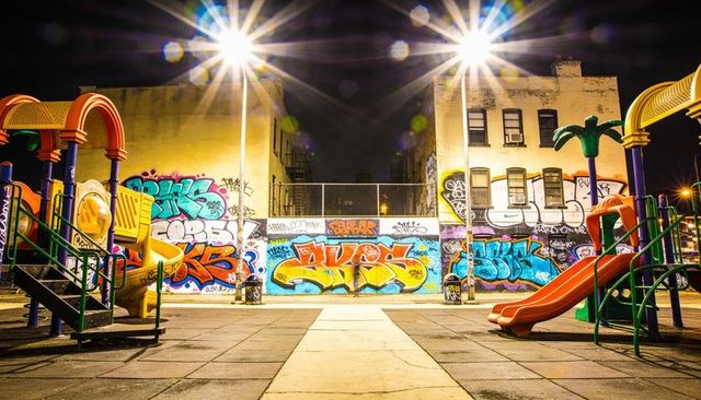 Illuminating urban playground showcasing colorful graffiti murals, glowing slides and street lamps
