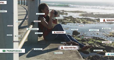 Woman Photographing Scenic Shore with Digital Tags Overlay