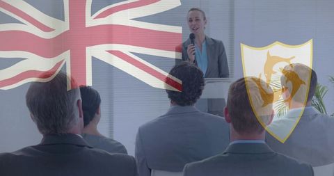 Businesswoman presenting to corporate audience with union jack and anguilla shield overlays