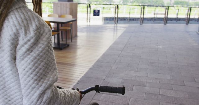 Person Walking with Bicycle in Cozy Outdoor Café Area - Download Free Stock Images Pikwizard.com