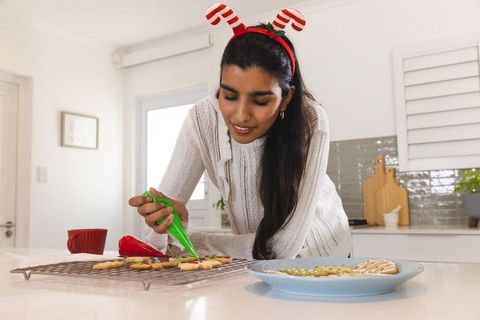 Woman Decorating Holiday Sugar Cookies in Modern Kitchen