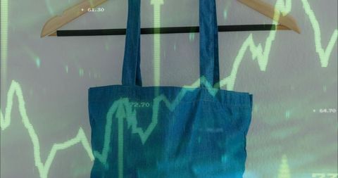 Hanging denim tote bag with green stock chart overlay on pastel wall for eco branding