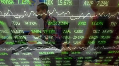 Coworkers Collaborating in Modern Office with Stock Market Projections