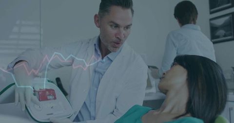 Doctor demonstrating defibrillator use in training session